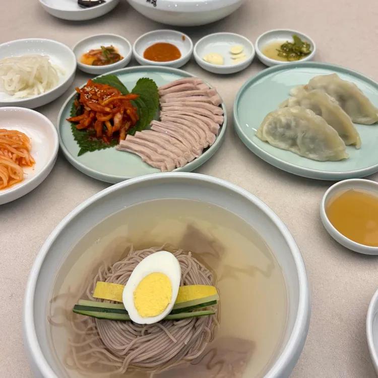 냉면과 편육, 만두와 여러 반찬을 함께 차린 식탁