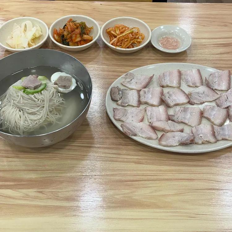 평양냉면과 돼지고기 제육을 넉넉하게 차린 식탁