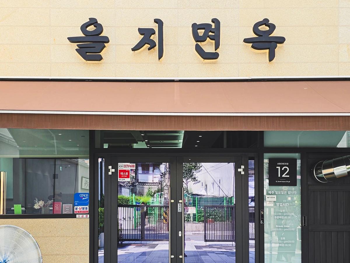 베이지색 외벽에 검은 을지면옥 간판이 걸린 종로 낙원동 매장 입구