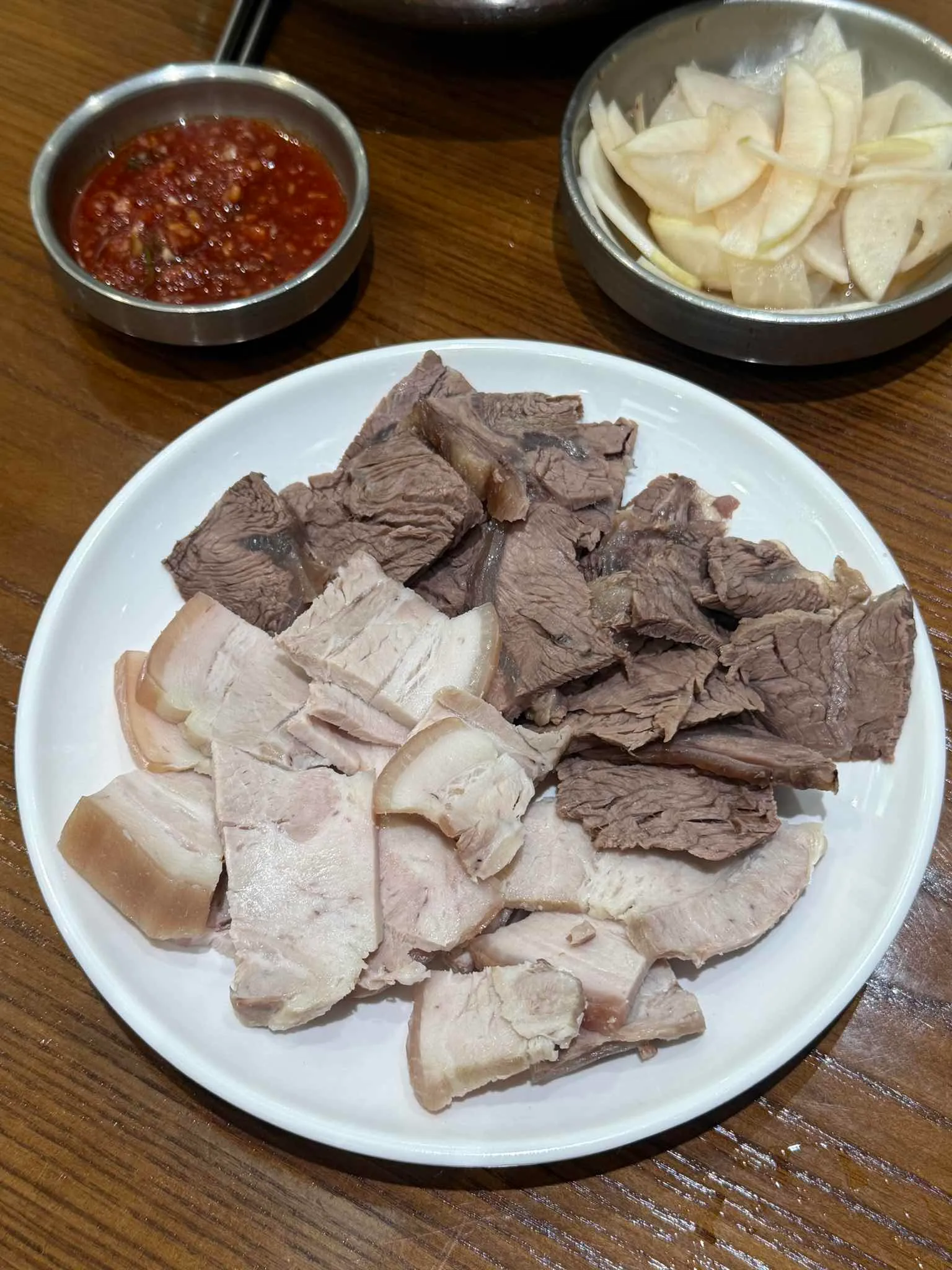 돼지고기 편육과 소고기 수육을 반씩 담고 무절임과 양념장을 곁들인 을지면옥 편수육
