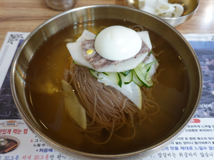 맑은 육수에 메밀 면과 배, 오이, 고기, 삶은 달걀을 올린 경인면옥 평양물냉면