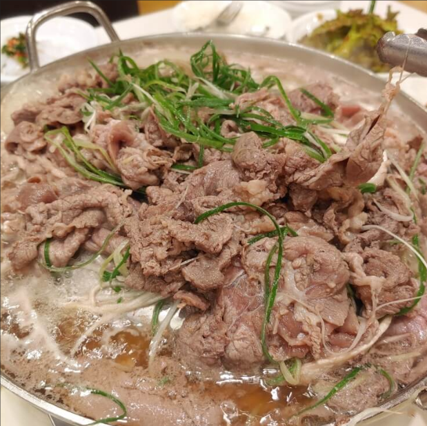 육수와 대파를 곁들여 끓이는 신촌 형제갈비의 불고기 한 판