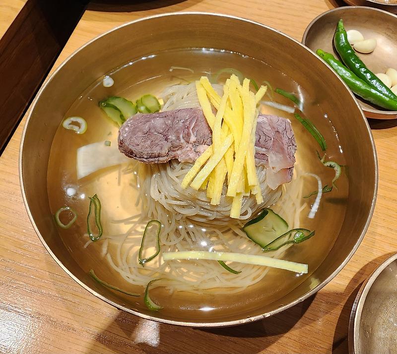 맑은 육수에 메밀 면과 소고기, 달걀지단, 오이와 무를 올린 능라도 평양냉면