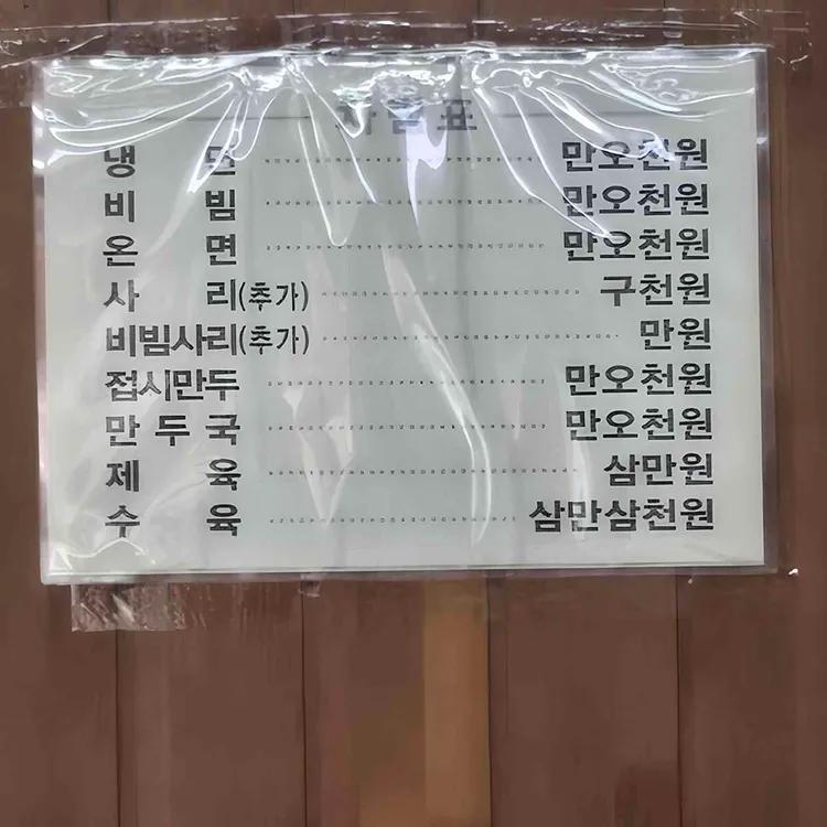 냉면과 비빔, 온면, 사리, 만두, 제육, 수육 가격이 적힌 필동면옥 메뉴판
