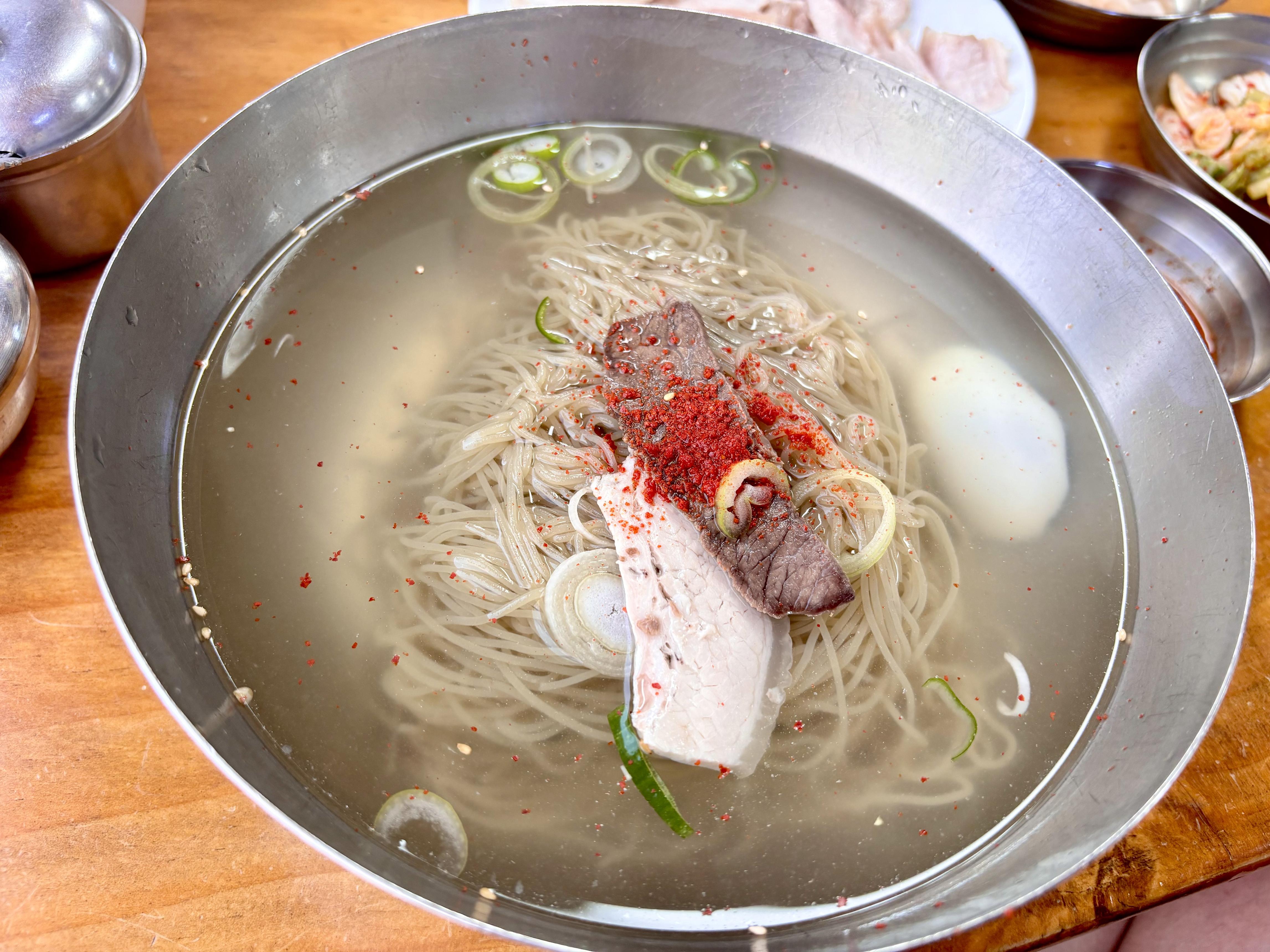 맑은 육수에 가는 면과 고기, 파, 고춧가루, 삶은 달걀을 올린 필동면옥 평양냉면