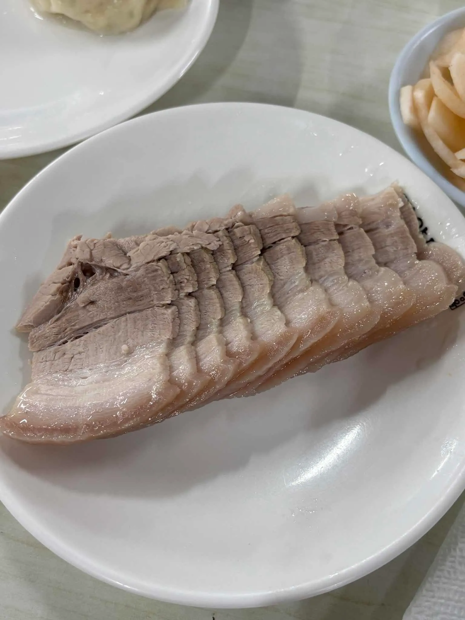 흰 접시에 얇게 썬 돼지고기 제육을 담은 장충동 평양면옥 메뉴