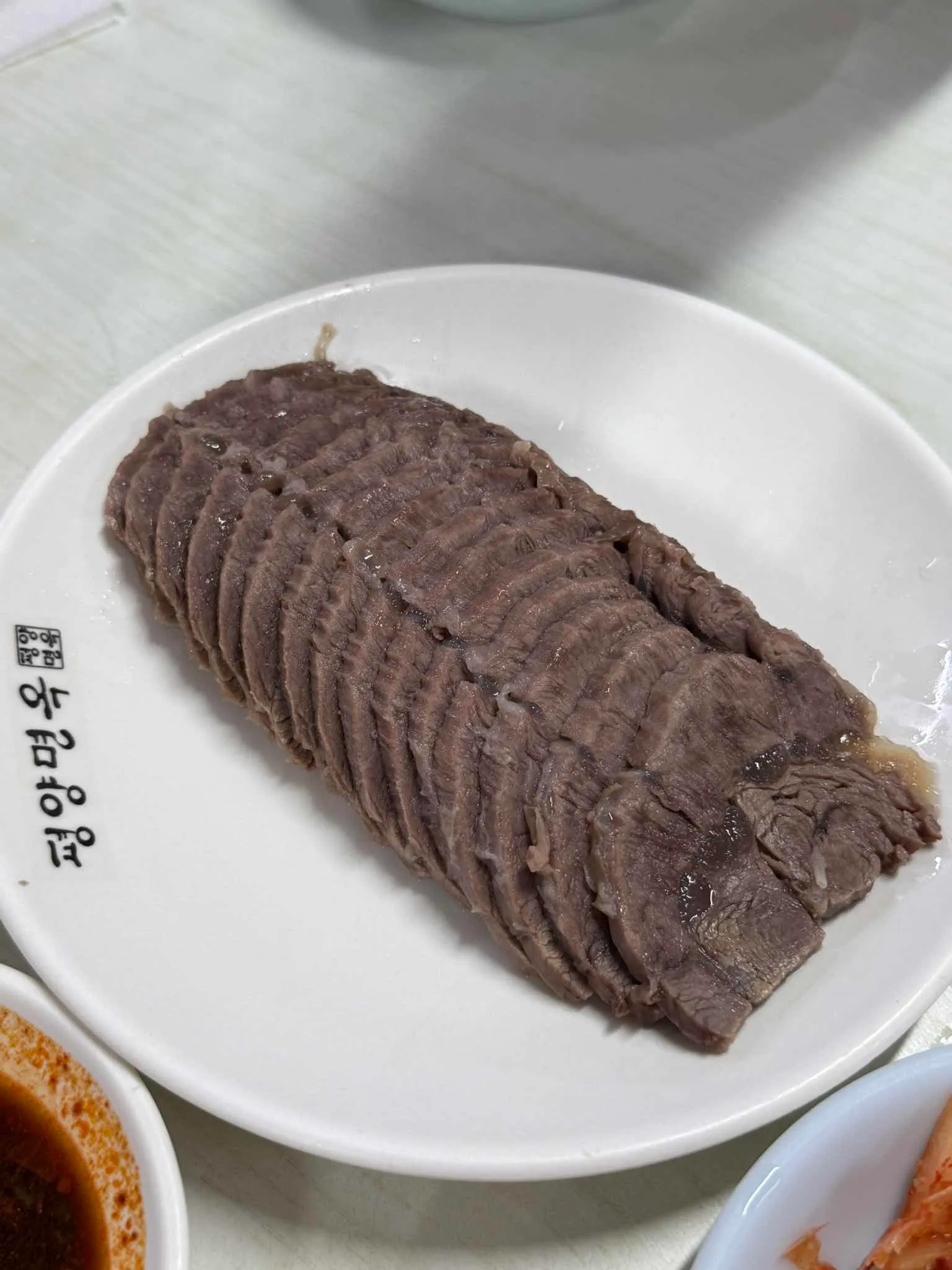 평양면옥 글자가 적힌 흰 접시에 소고기 편육을 가지런히 담은 모습