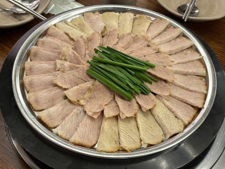 둥근 접시에 가지런히 담은 돼지고기 수육